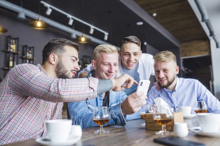 Un grupo de amigos comparte un momento alrededor de un m&oacute;vil